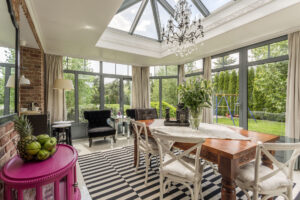 A sunroom with dining table and a chandelier